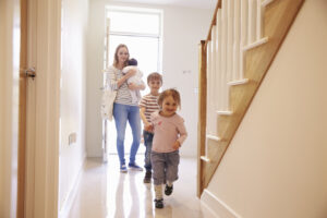 A young family looking around a property with good air quality, which is one of the benefits of painting your home.