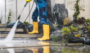 A man pressure washing a driveway, showcasing professional pressure washing services.