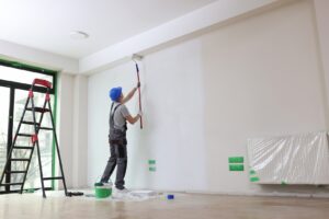 A worker is painting a wall with a paint roller, demonstrating the precision and care taken by painters Wichita KS.