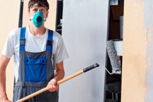 A professional painter is holding a paint roller, ready to apply paint to a surface, representing the skill and expertise of Wichita painters.