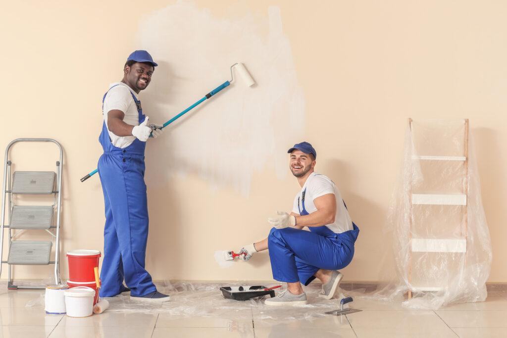 Two house painters smiling at the camera, representing local painting companies.