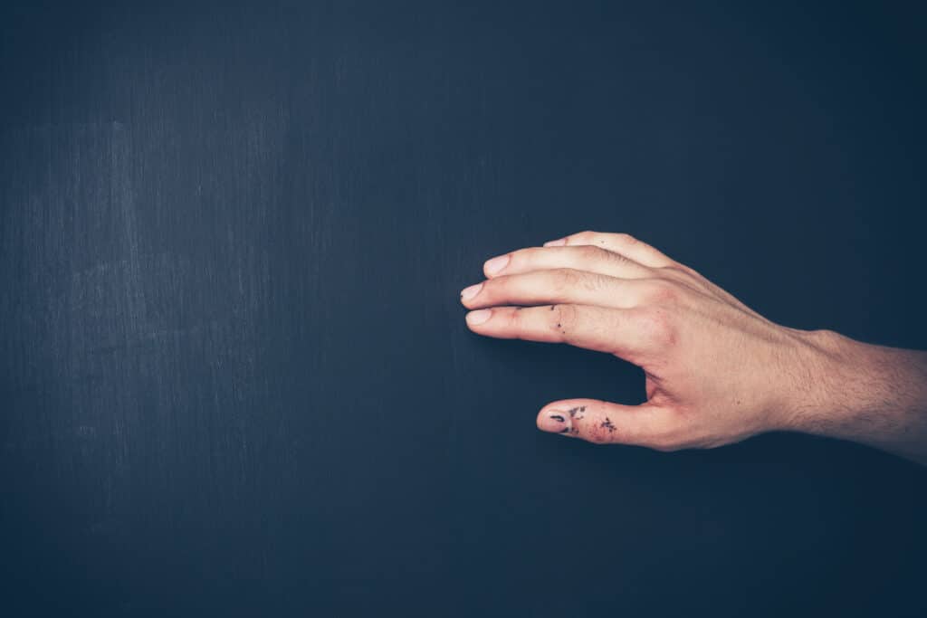 A person caressing a freshly painted wall and accidentally getting paint on their hand, illustrating the importance of allowing proper drying time for freshly painted walls.