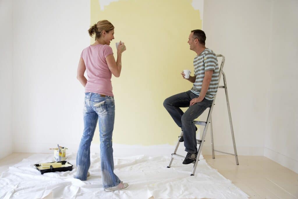 A person cleaning a wall before painting, demonstrating the steps involved in how to clean walls before painting to ensure a smooth application.