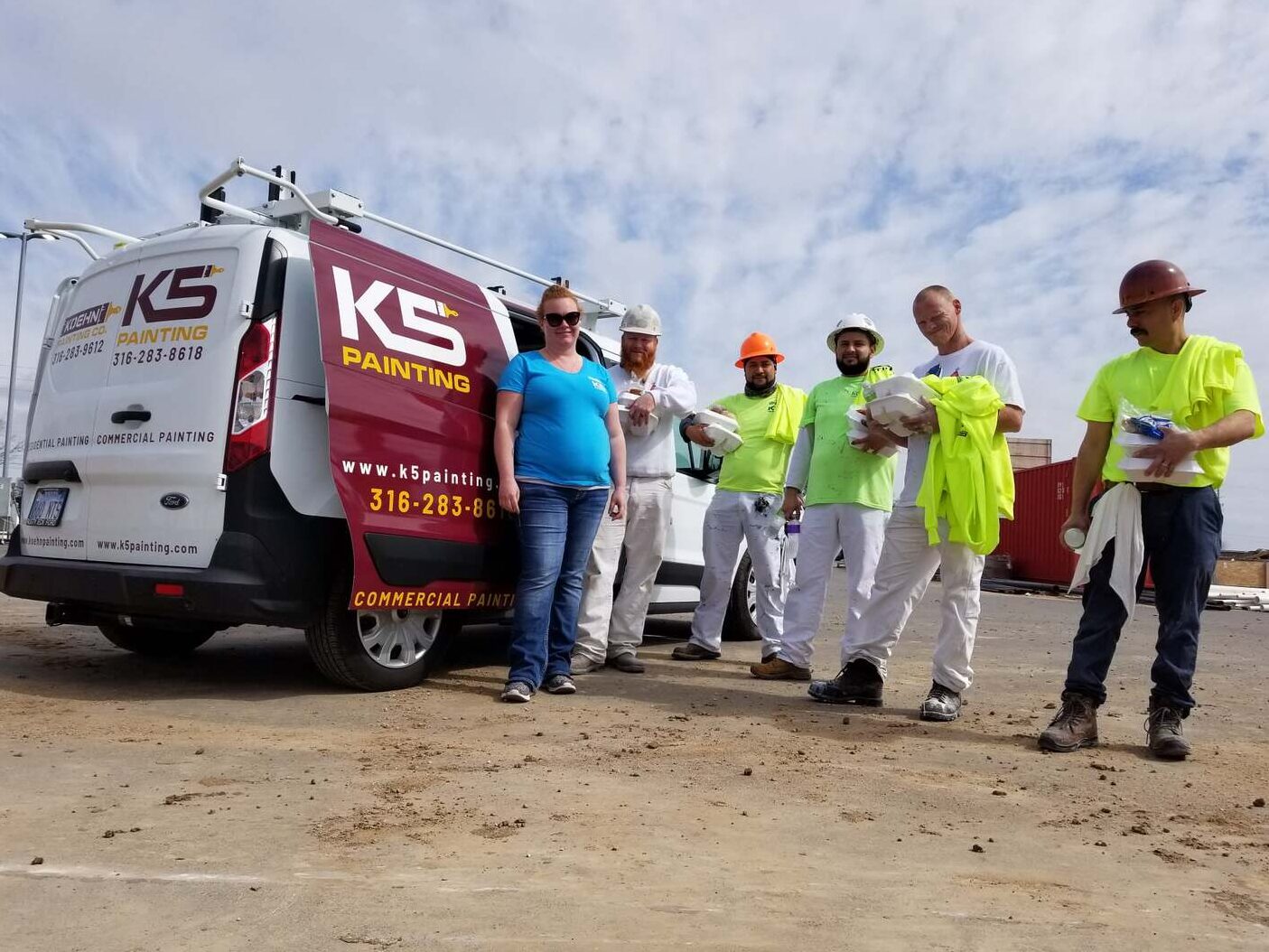 A group of professional painters standing next to a van marked "K5 Painting," offering specialized services for painters in Wichita KS.