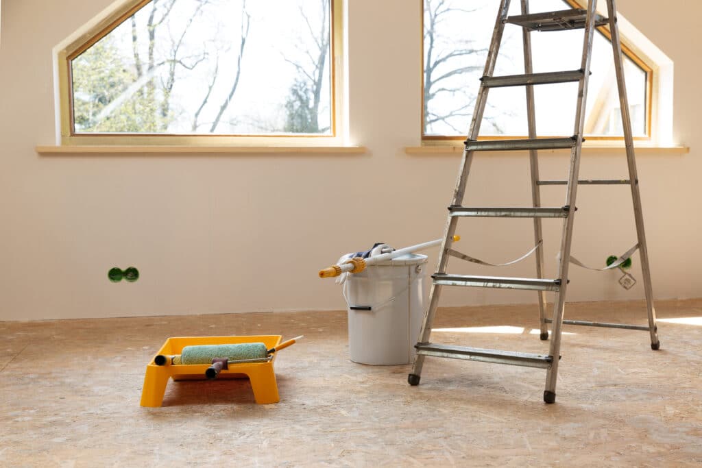 A room prepared for painting with tools and a ladder, showing preparation work for house painters Wichita KS.