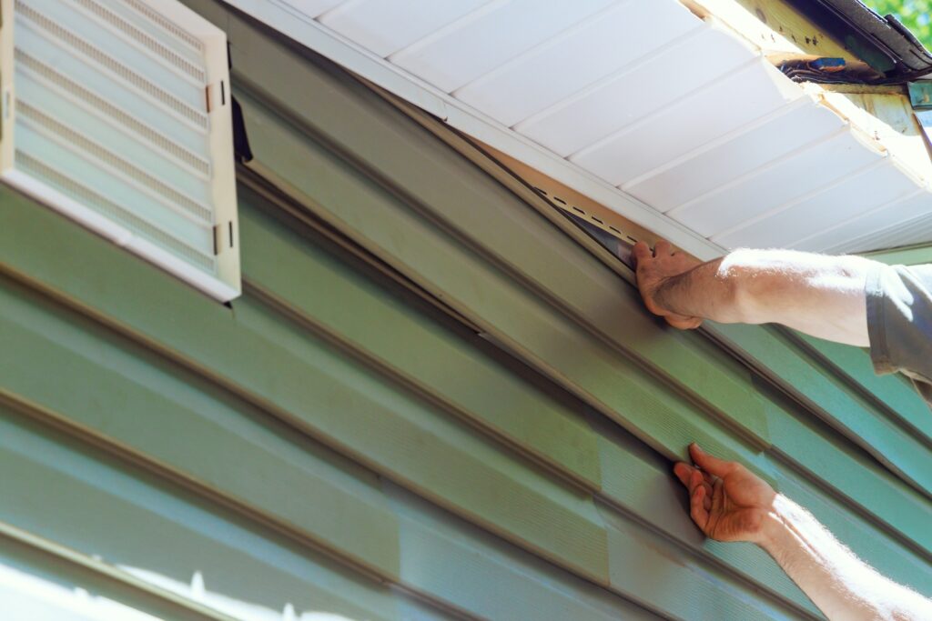 Expert aligning vinyl siding, demonstrating the care provided by top siding companies in Wichita KS.