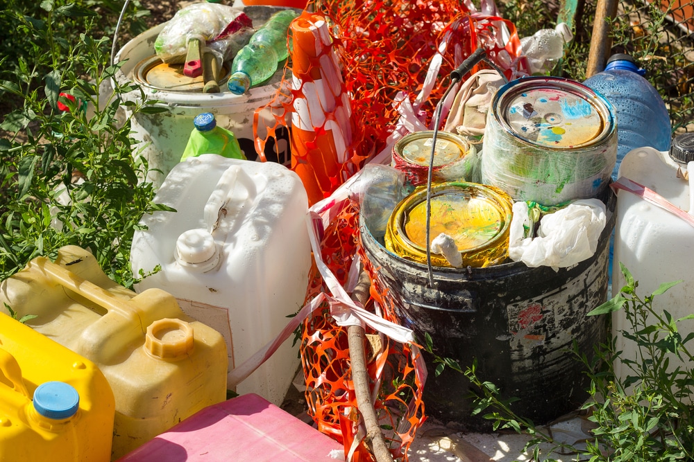 Pile paint cans, plastic containers, and construction debris, highlighting the need for eco-friendly commercial interior painting practices