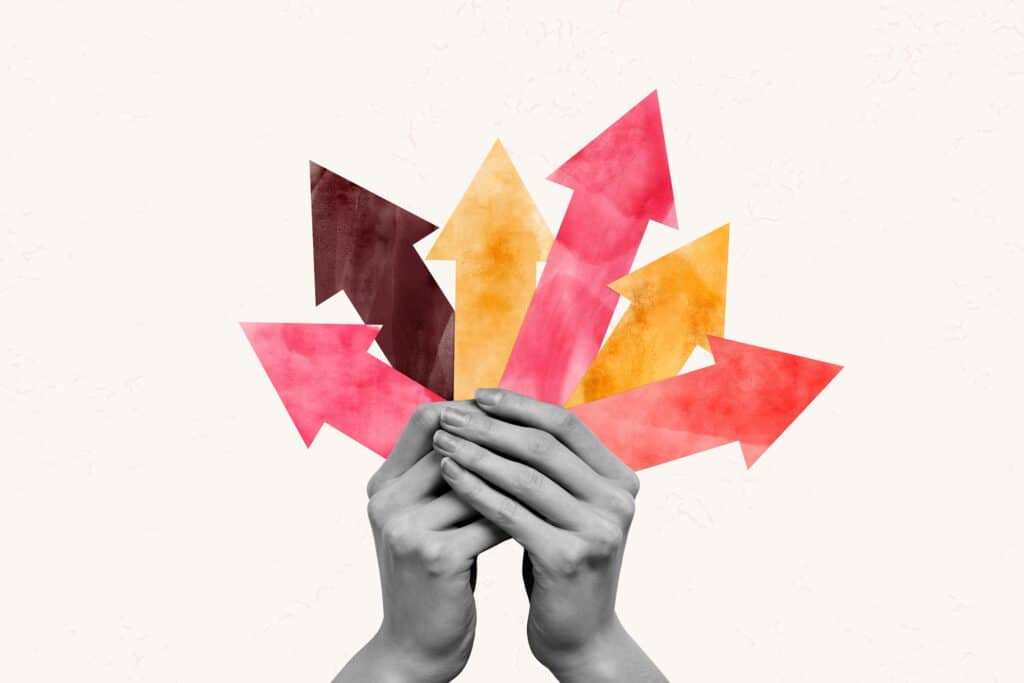 Illustration of vibrant arrows in shades of red, orange, and pink held in hands, symbolizing growth and exploration in answering the question 'What color promotes productivity?'