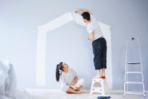 A couple who are in need of quick painting services in Kansas, attempting to paint the walls of their home.