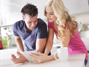 A couple performing some online research, before they settle on hiring a professional painter.