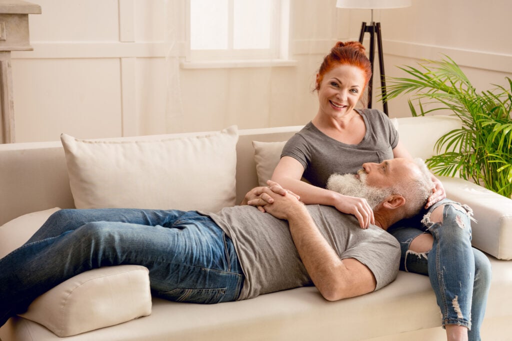 A happy couple in their home after hiring one of the best paint contractors for an interior paint job. 