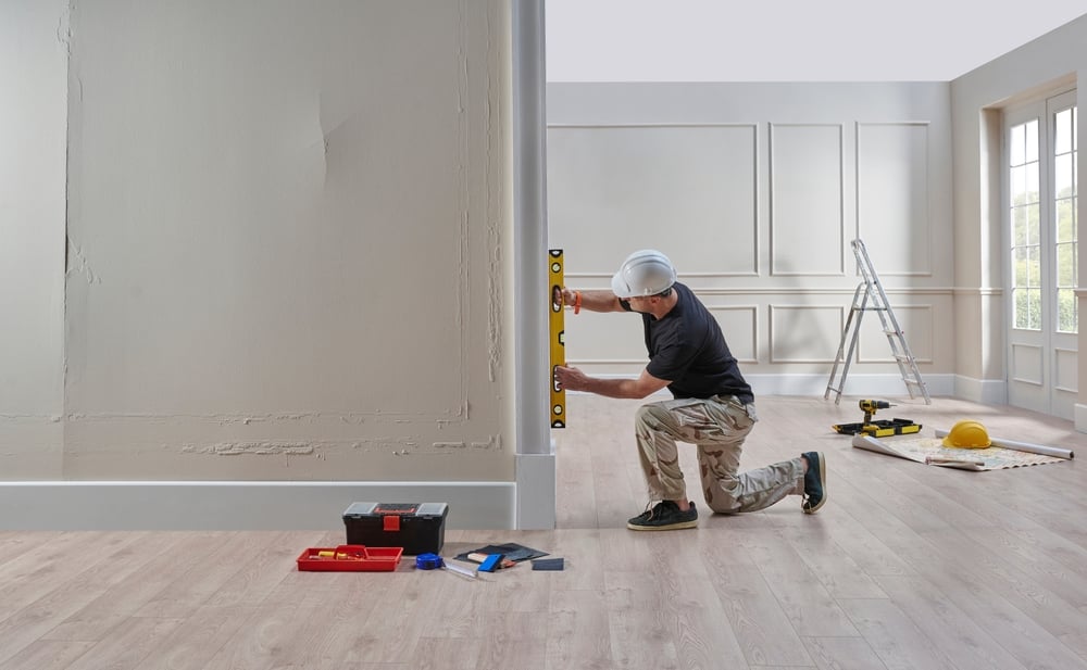 Worker using a level during a home renovation, symbolizing the types of projects homeowners take on after financing home improvements.