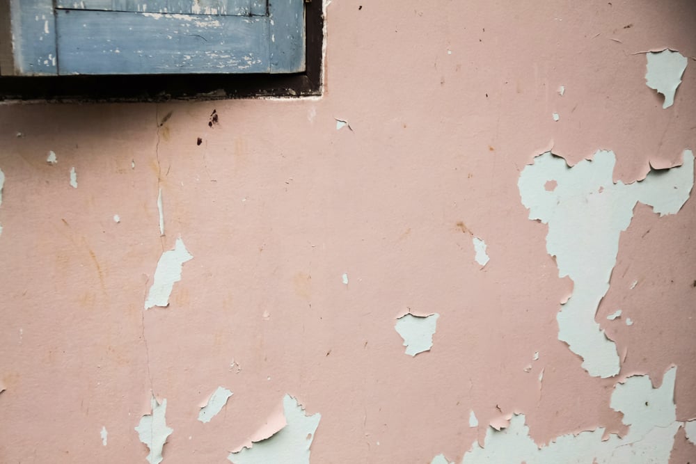 Peeling paint on wall showing a mistake people make when hiring painters with poor prep work.