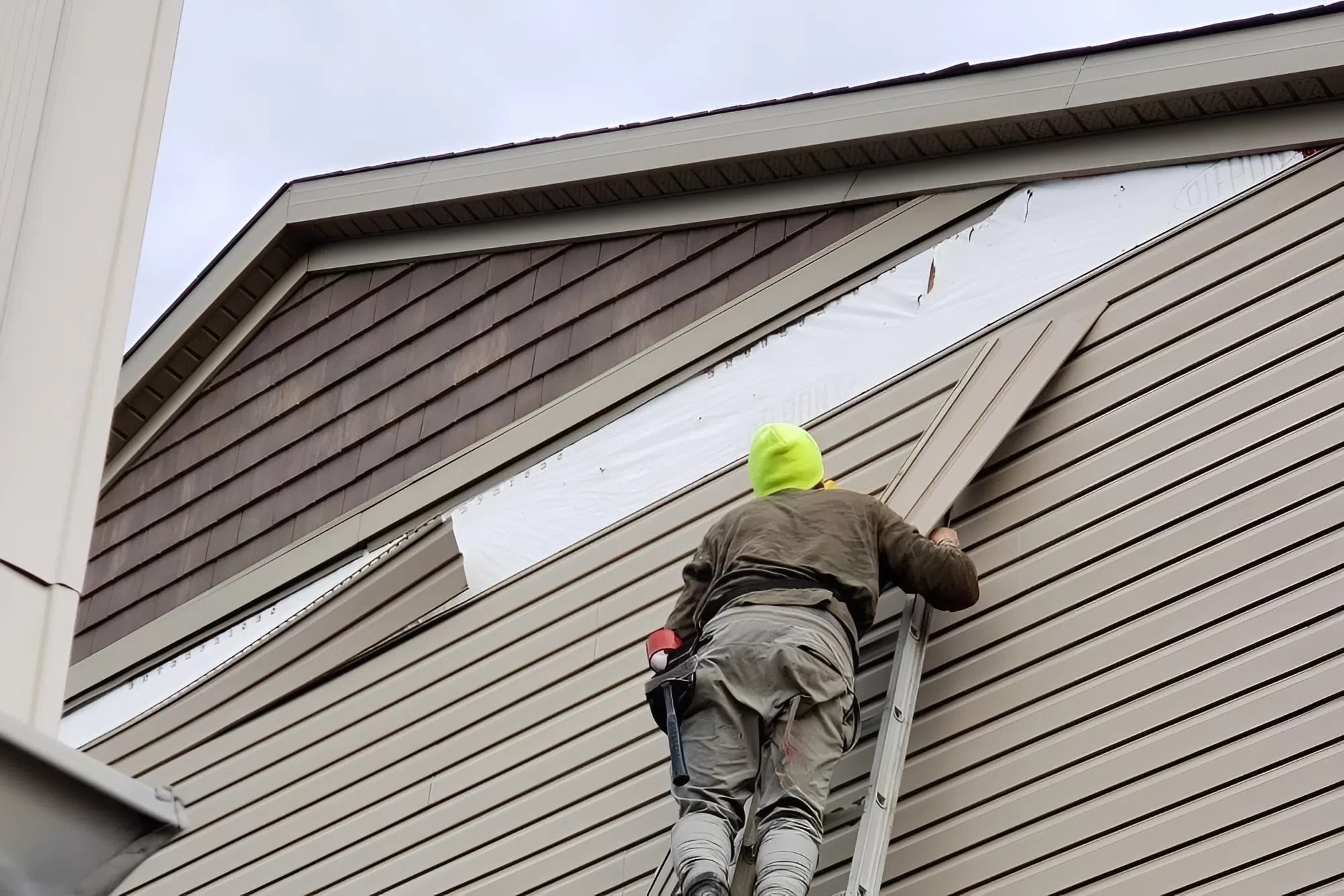 Exterior siding repair in progress by a painter in Andover, KS, preparing damaged areas before painting
