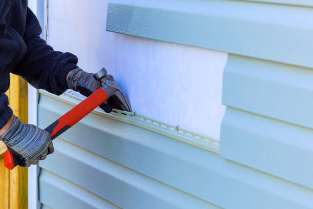 Repairing damaged siding before a painting project by an exterior painter in Wichita, KS.